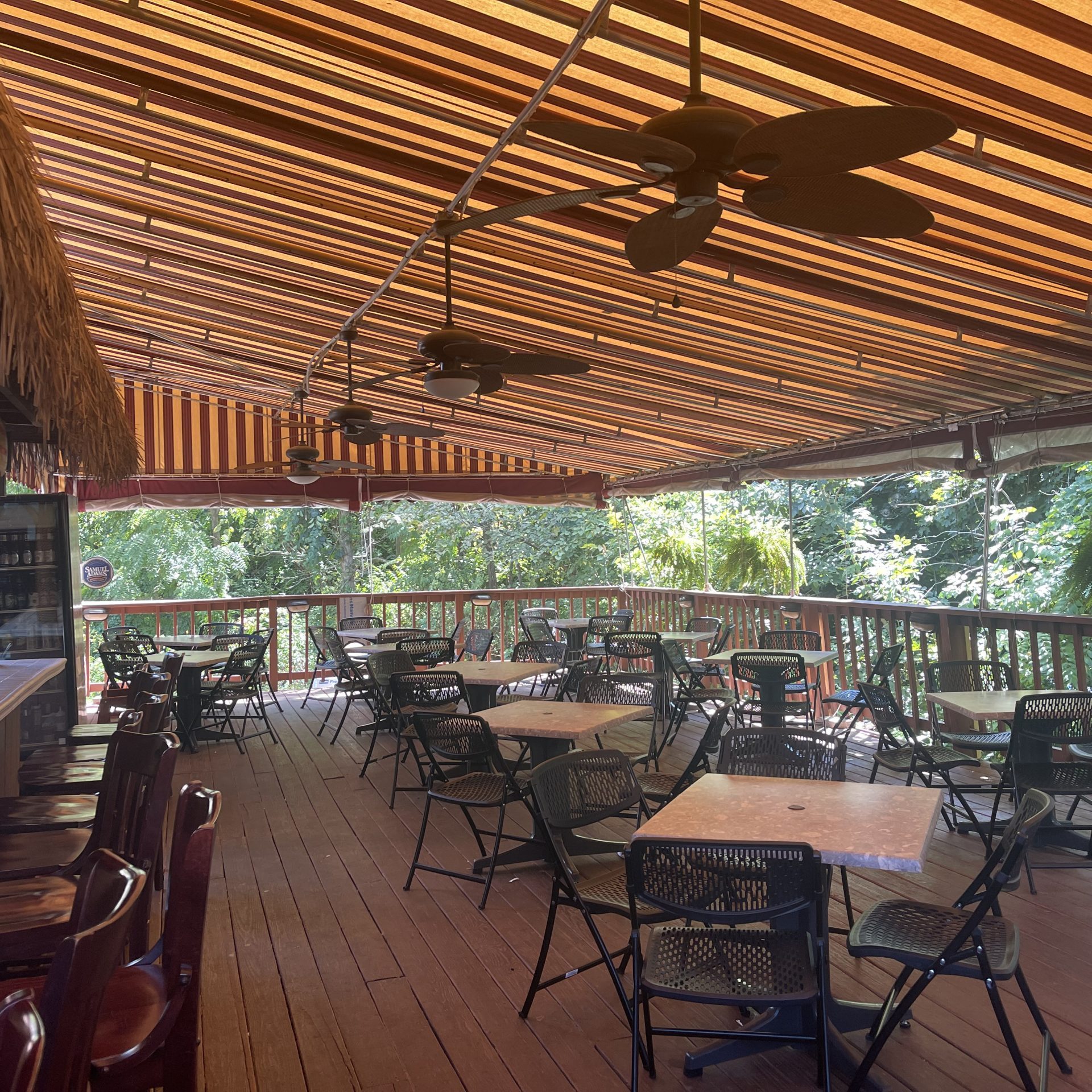 A wooden deck with tables and chairs.